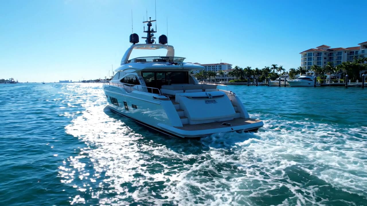 Stern view of a white motor yacht underway on bright blue water